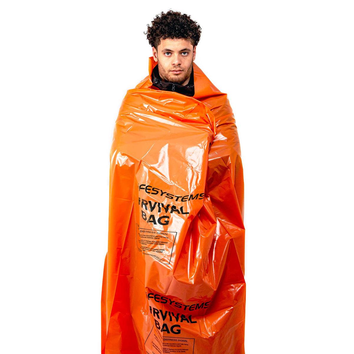 Person wrapped in an orange Lifesystems Survival Bag